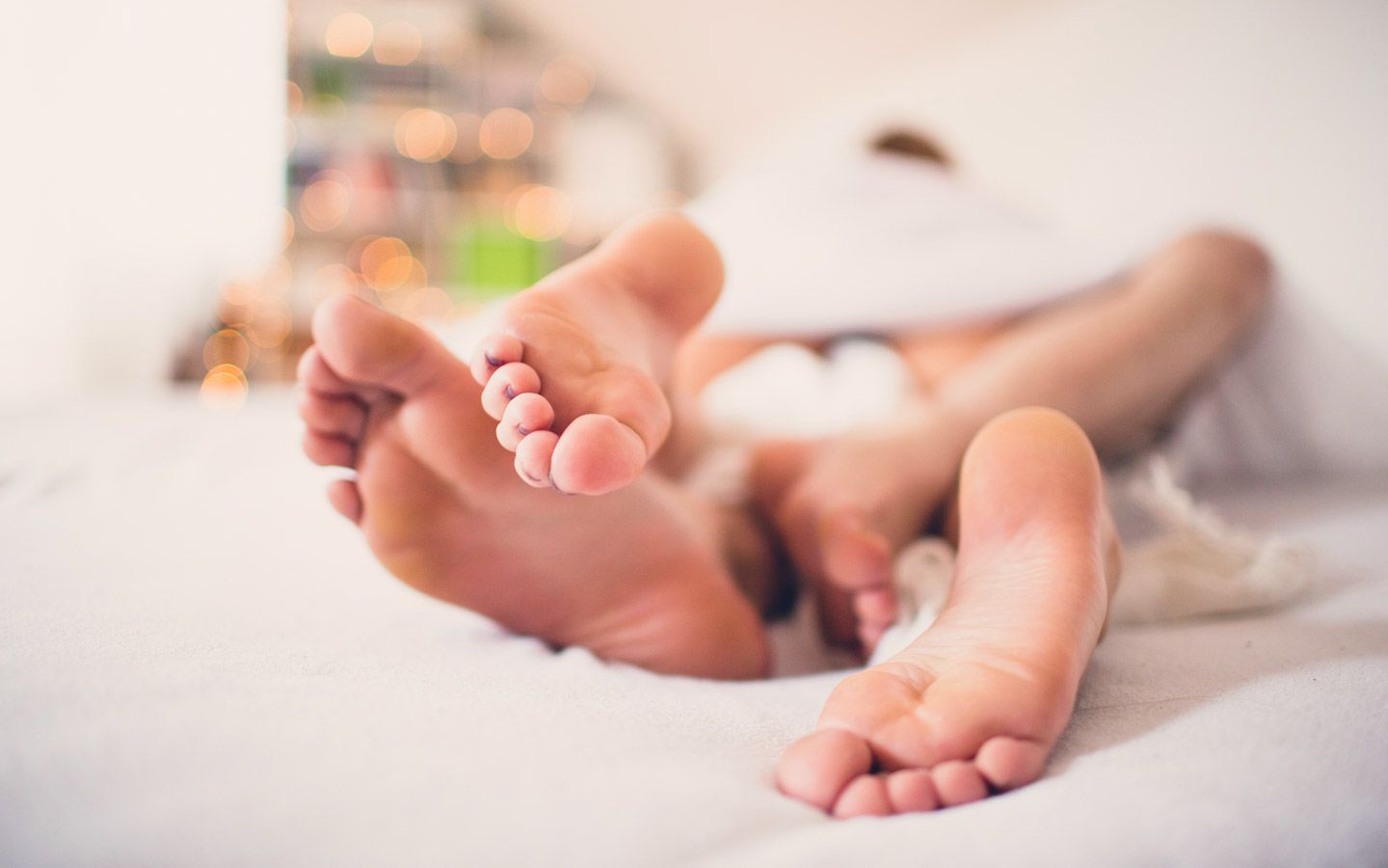 Føttene til noen som ligger sammen i en seng