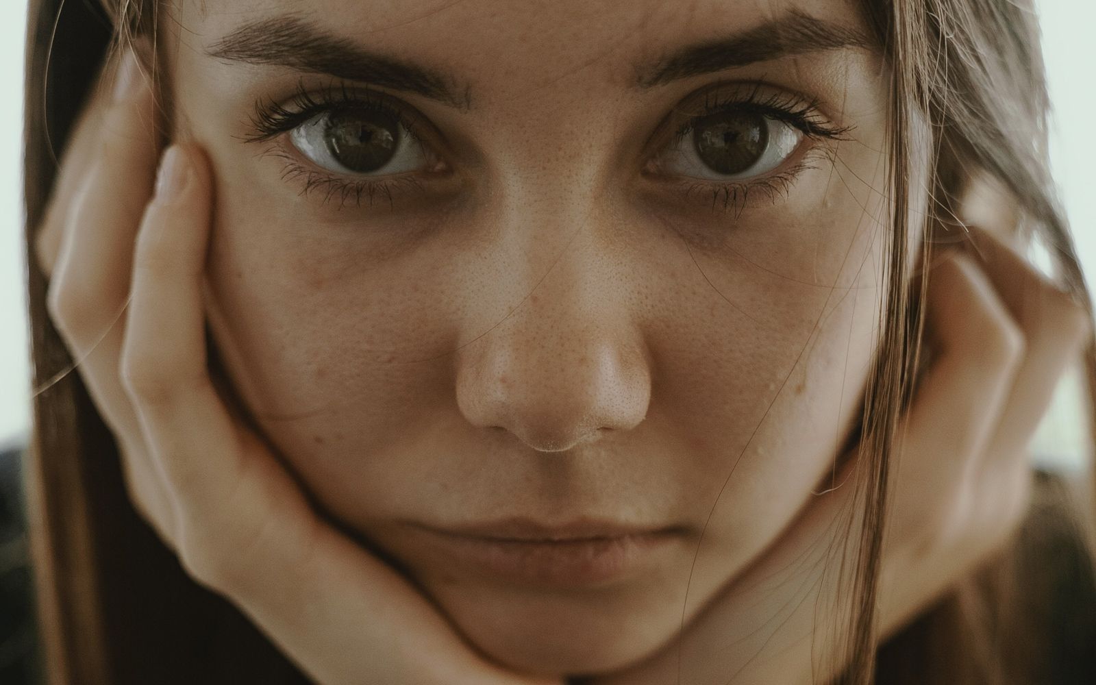 Et nærbilde av ansiktet til en jente som ser alvorlig inn i kameraet
