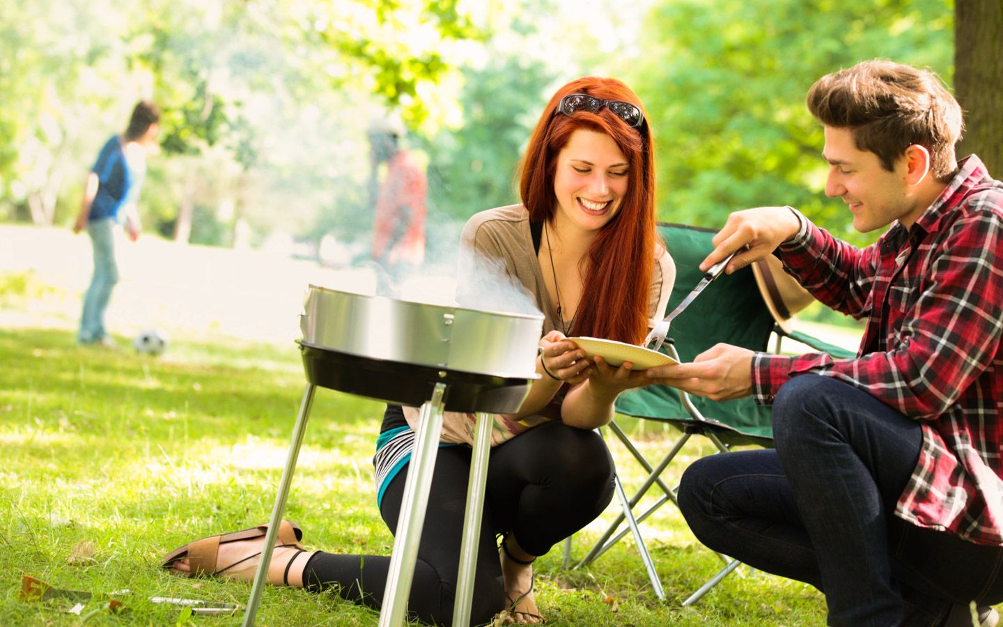 Hepatitt A Mann og kvinne smiler ved en grill. Det er feriestemning