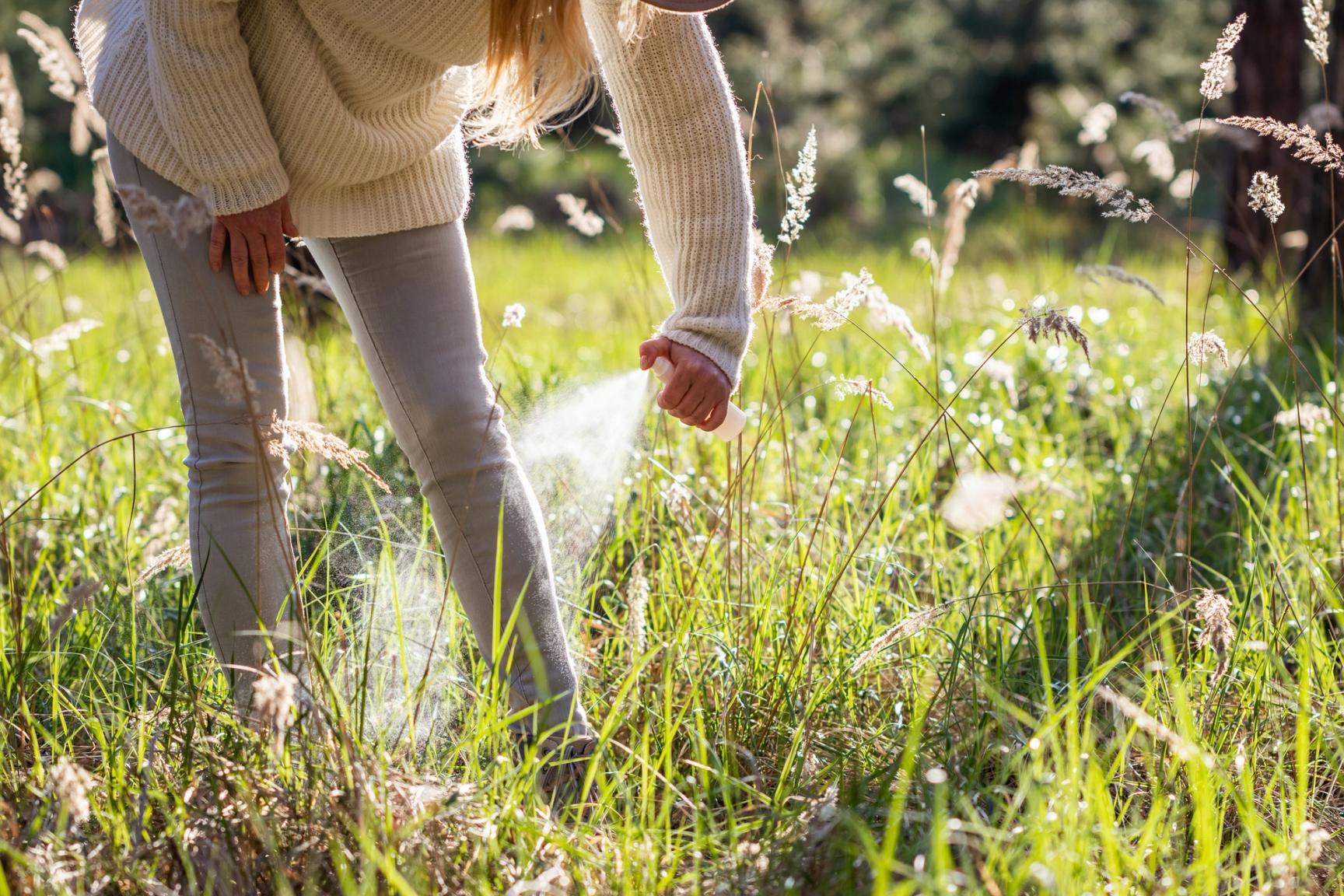Kvinne sprayer seg med insektsmiddel