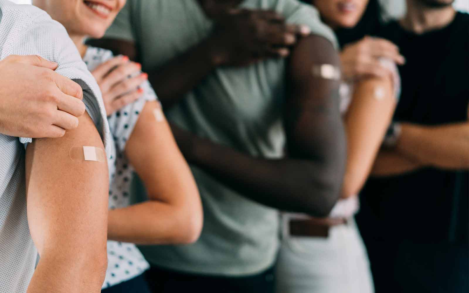 Utsnitt av flere armer med plaster på etter at vaksine er satt