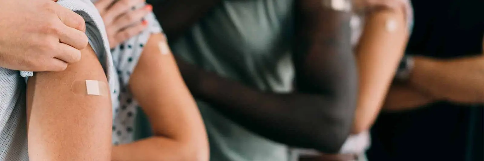 Utsnitt av flere armer med plaster på etter at vaksine er satt