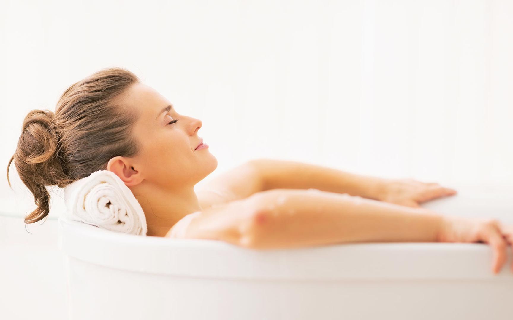 Dame som ligger pg slapper av i badekaret