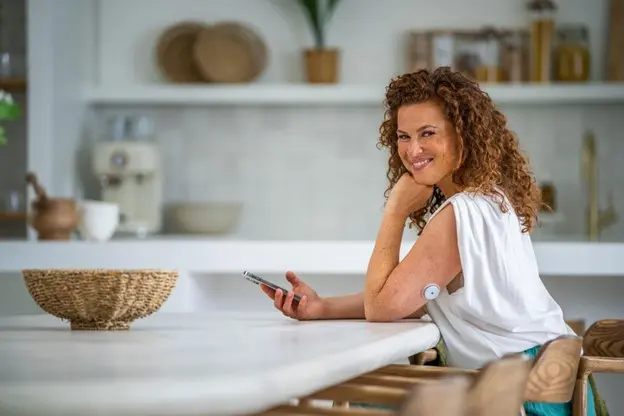 Kvinne med CGM sensor på armen