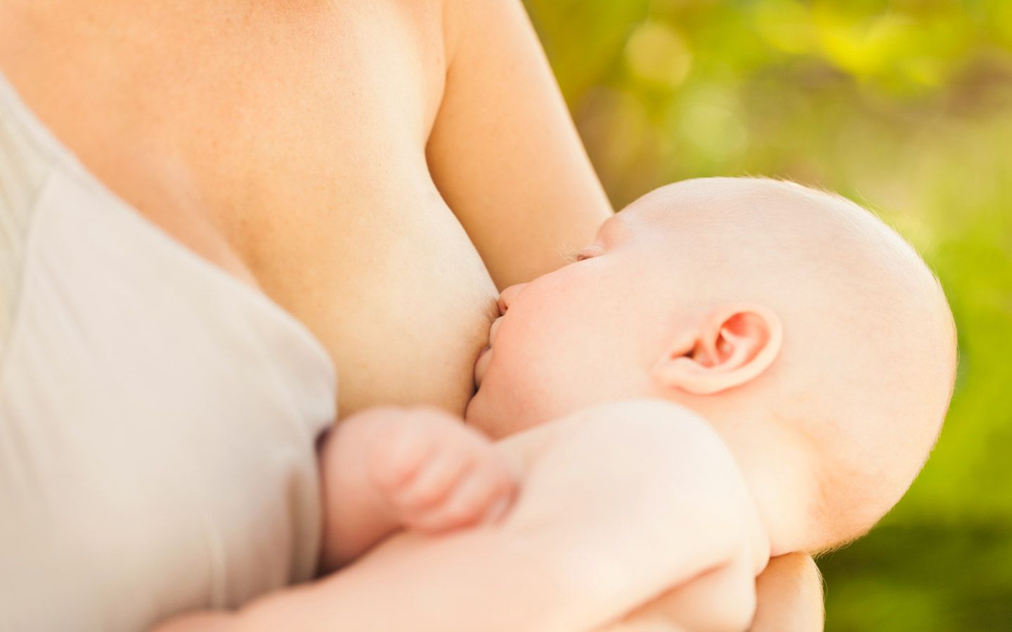 Bilde av baby som ammer av mors bryst.