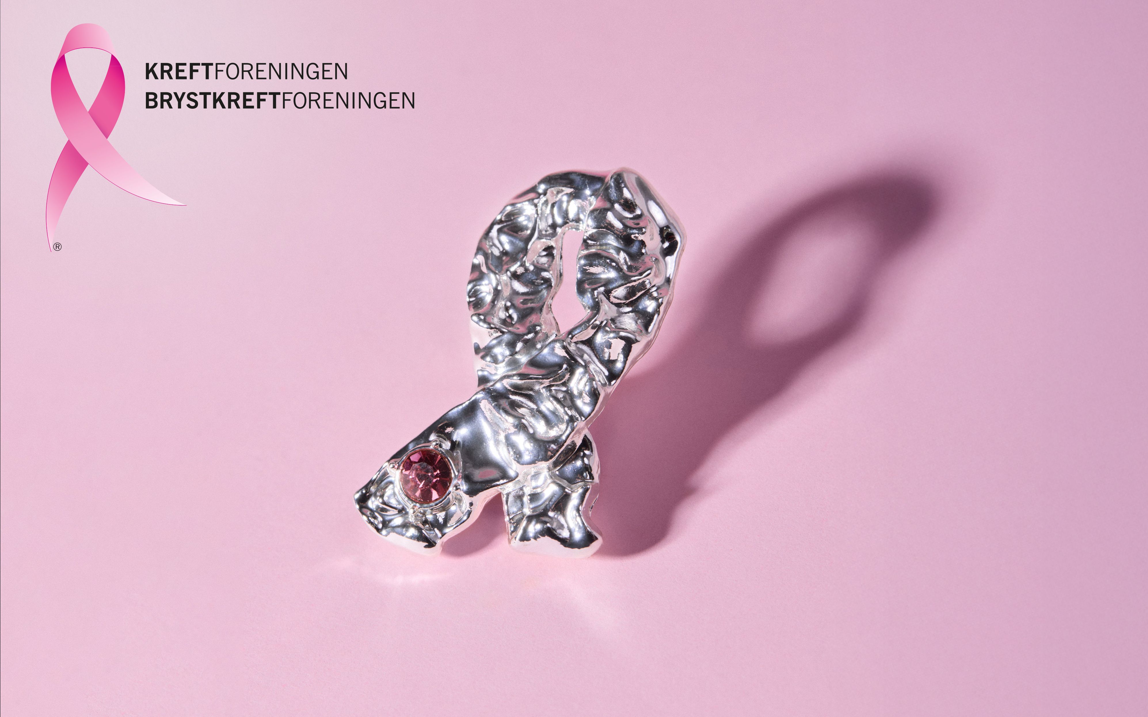 Nærbilde av årets rosa sløyfe brosje