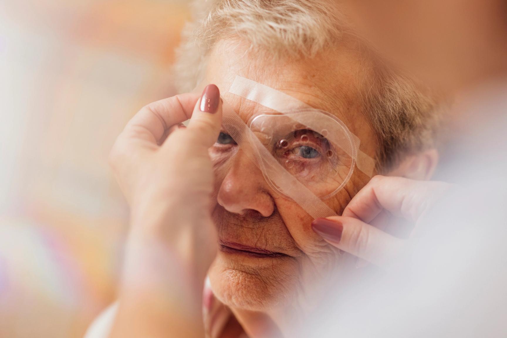 Eldre kvinne med beskyttende øyelapp etter øyeoperasjon