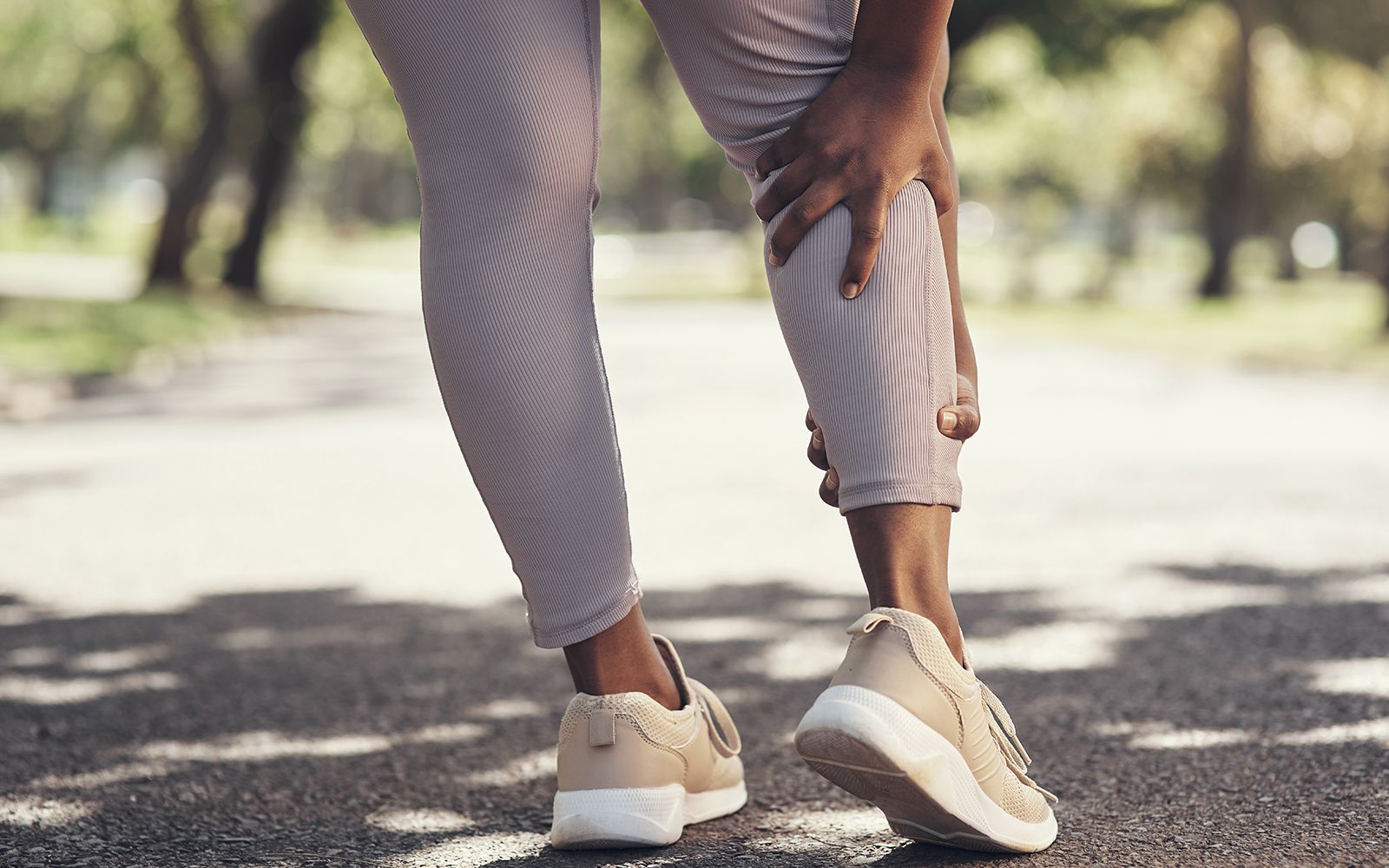 Kvinne som tar seg til leggen