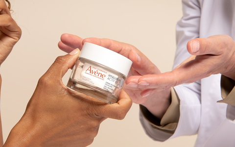 To personer holder en krukke med ansiktskrem fra Avène.