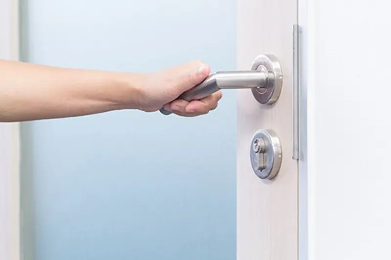Hånd på dørhåndtak