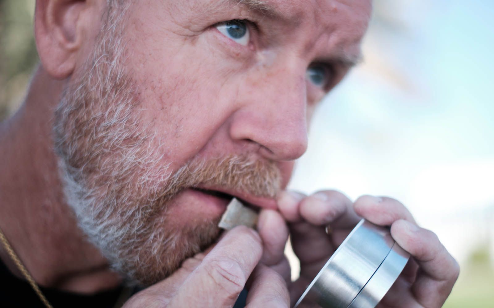 Mann legger porsjonssnus under overleppen