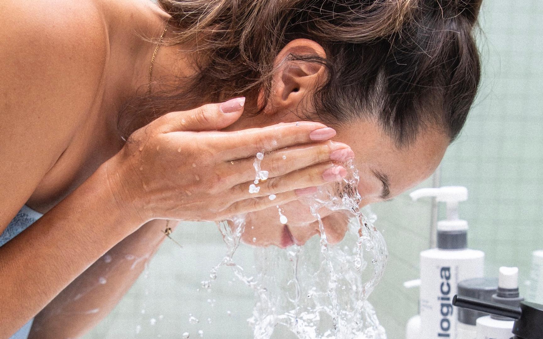 Bilde av en dame som vasker ansiktet sitt i vasken.