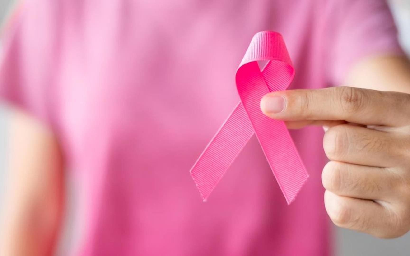 Person kledd i rosa som holder rosa sløyfe.