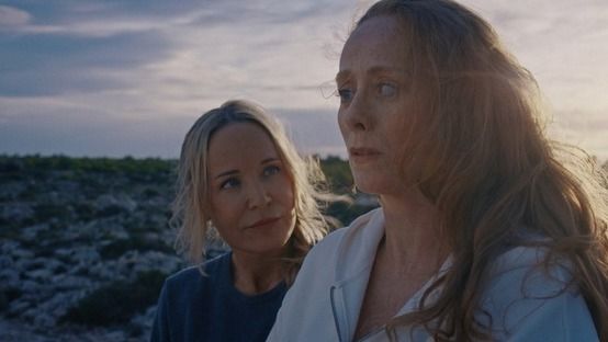 two women with a sunset background
