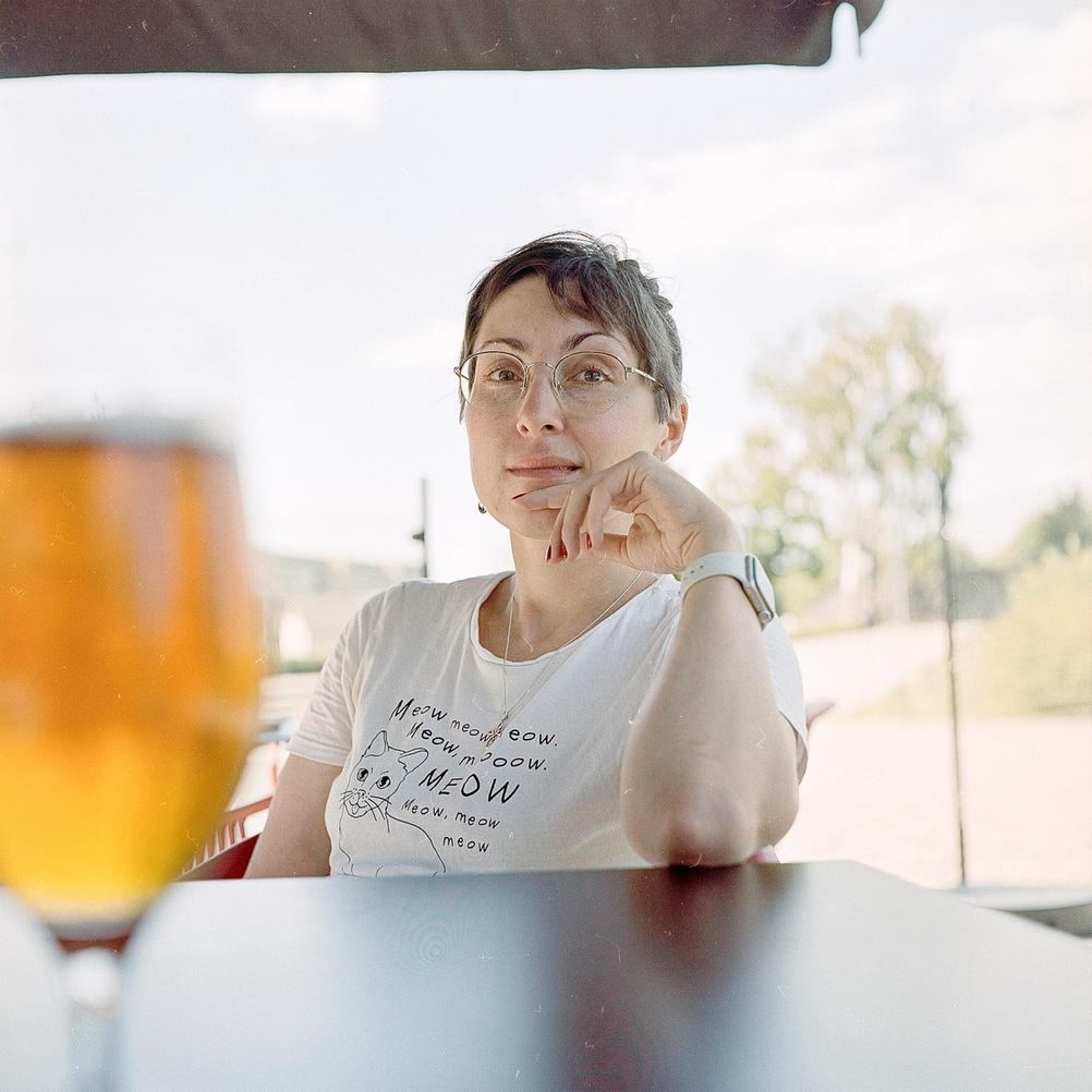 Photo of my wife with blurred beer in foreground.