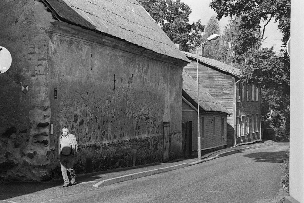 Photo of a man walking on street.