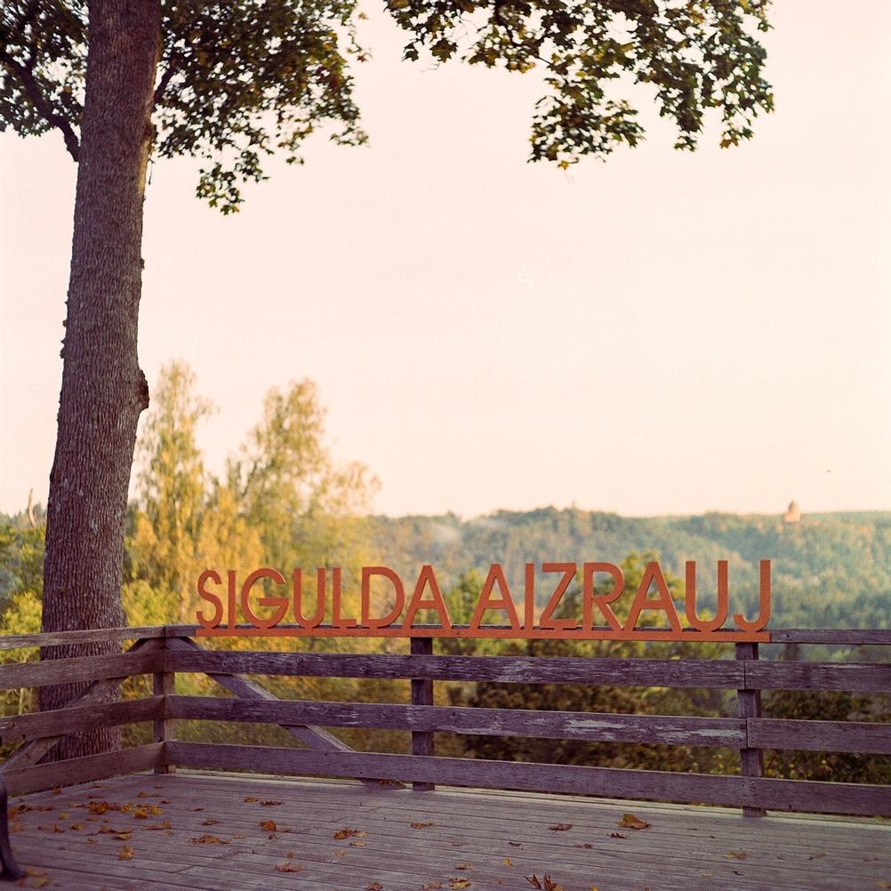 Photo of a text sign against a landscape backdrop.