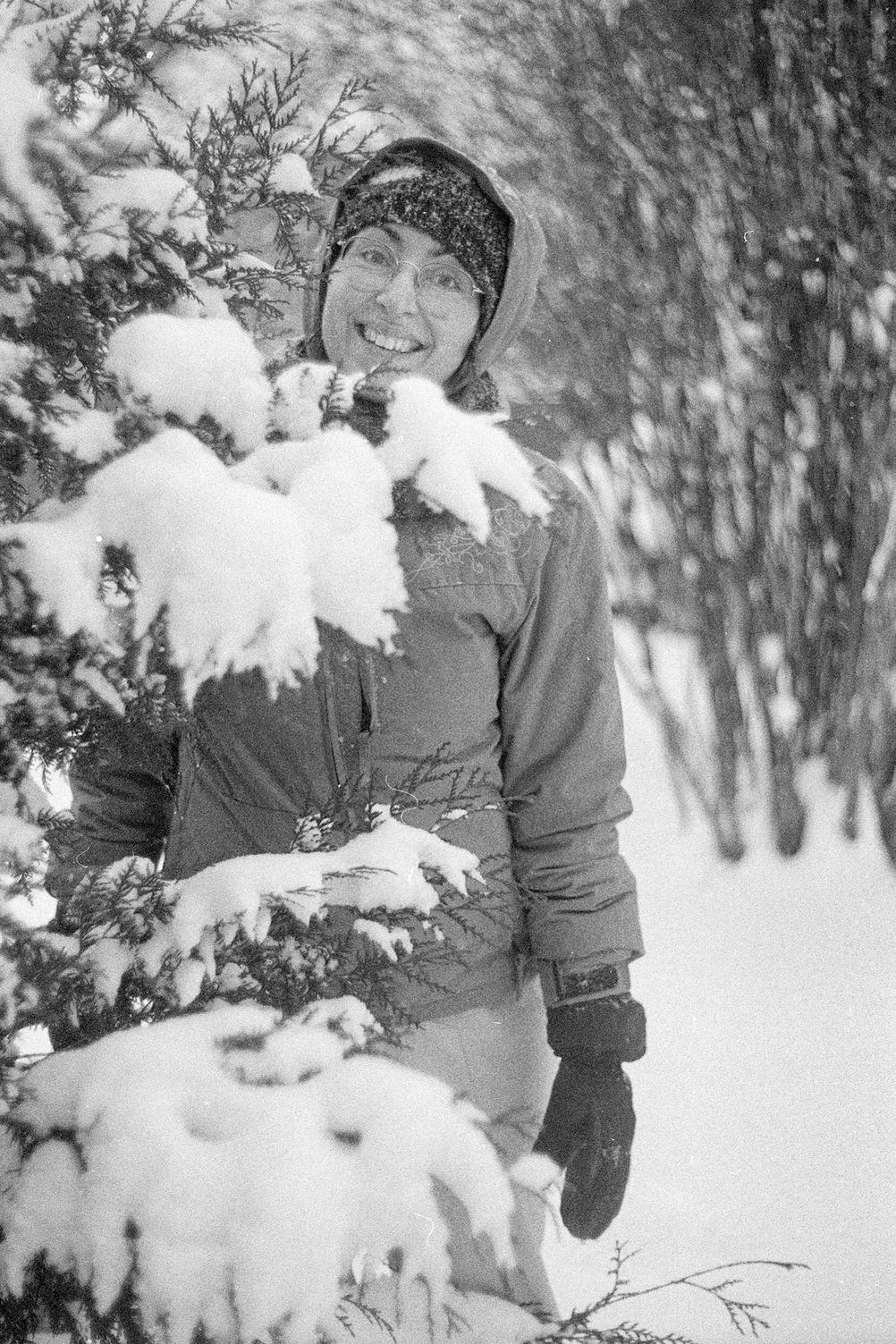 Photo of my wife next to a snowy tree.