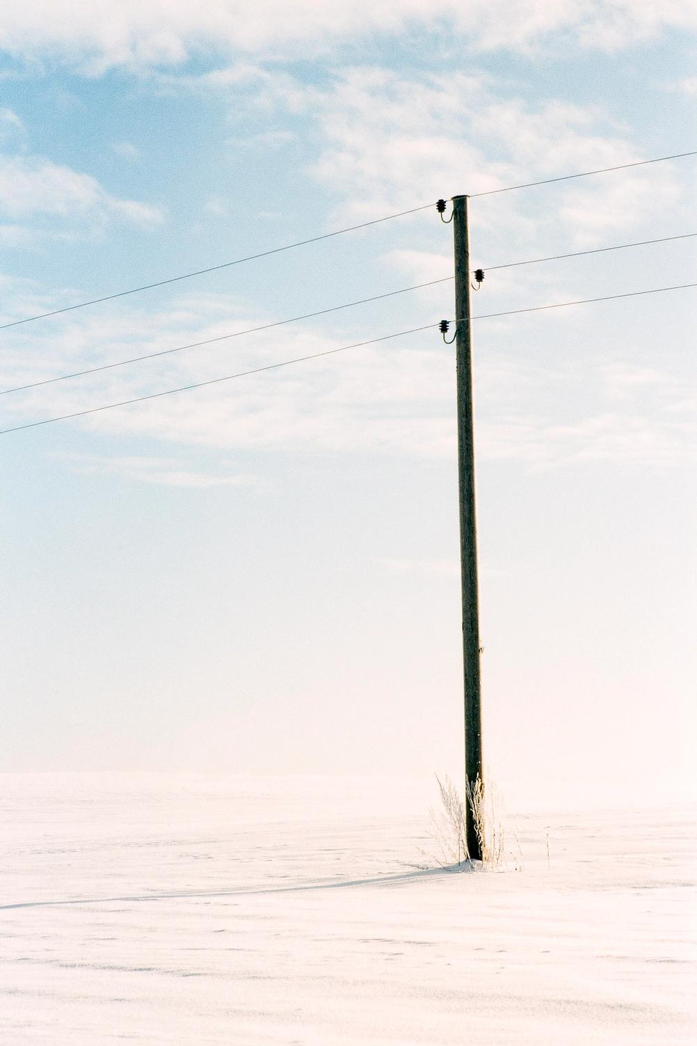 Photo of a lone pole in a field.