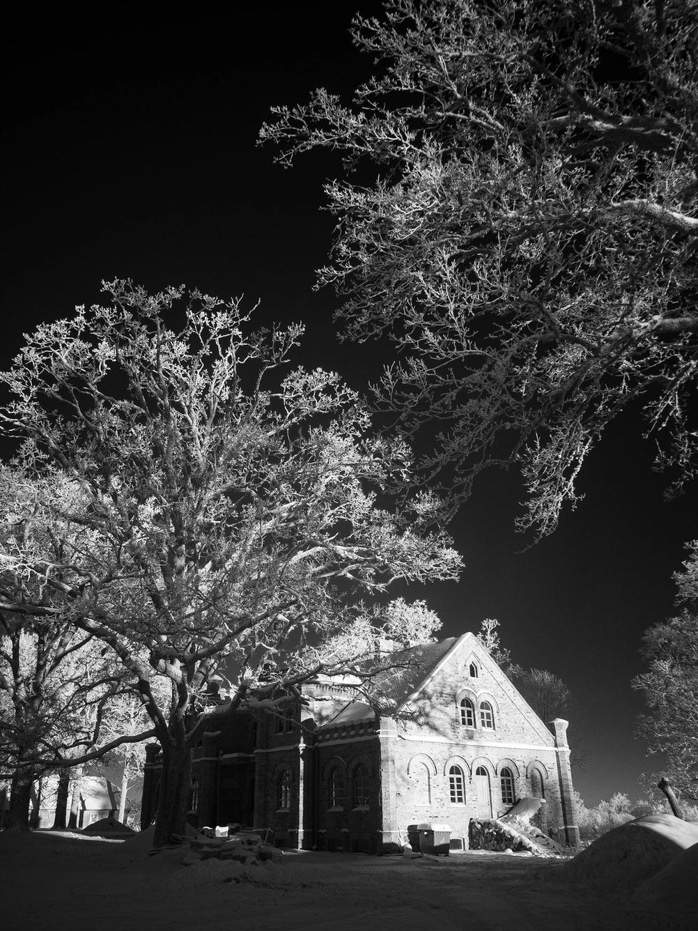 Photo of an old house being illuminated by sun as taken with an infrared camera.
