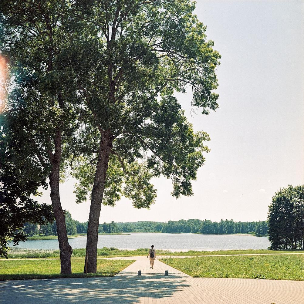 Photo of my wife in the distance walking towards a lake.
