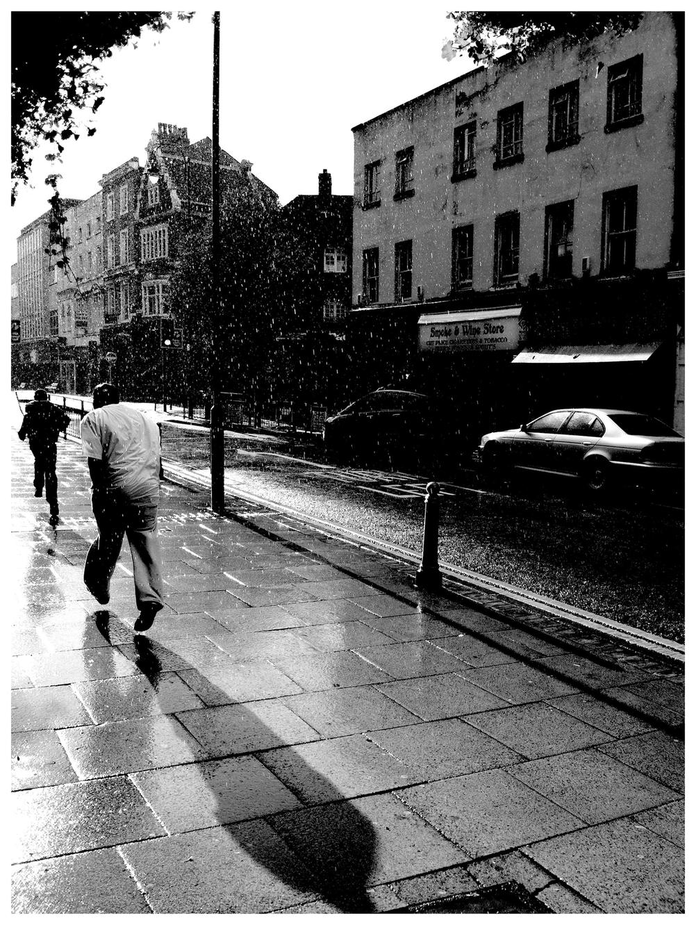 Photo of people running from rain.