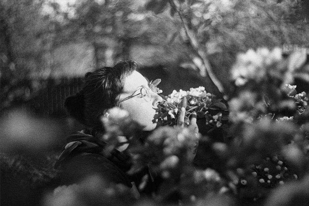 Photo of my wife sniffing blooming apple tree.