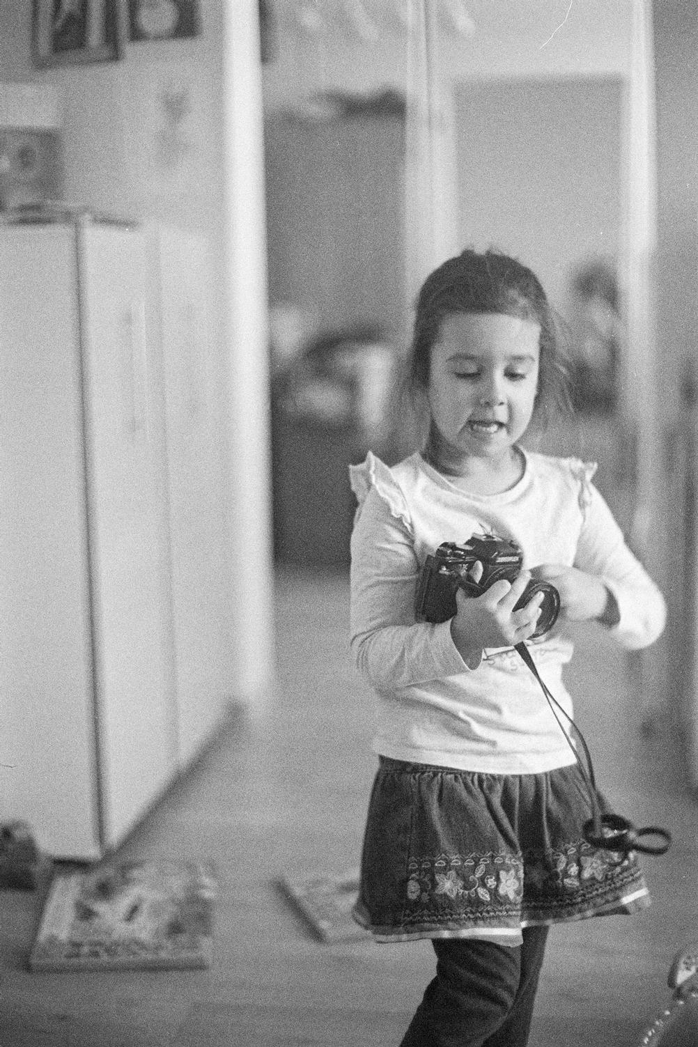 Photo of my daughter holding a film camera.