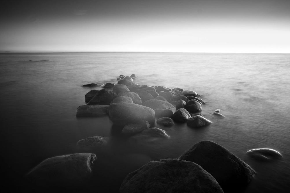 Photo of rocks reaching into the sea as taken with an infrared camera.