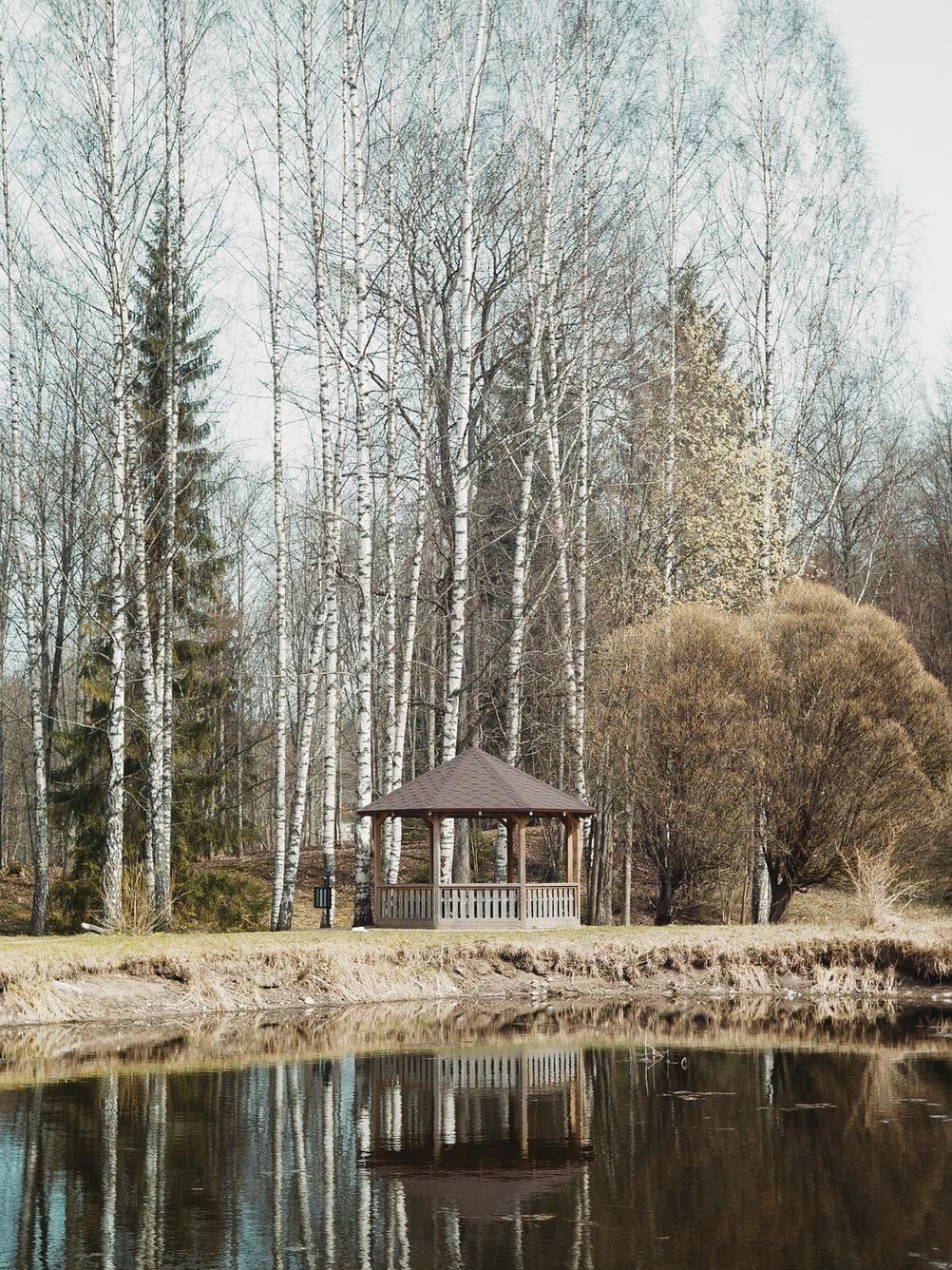 Photo of a small building reflected in a pond.