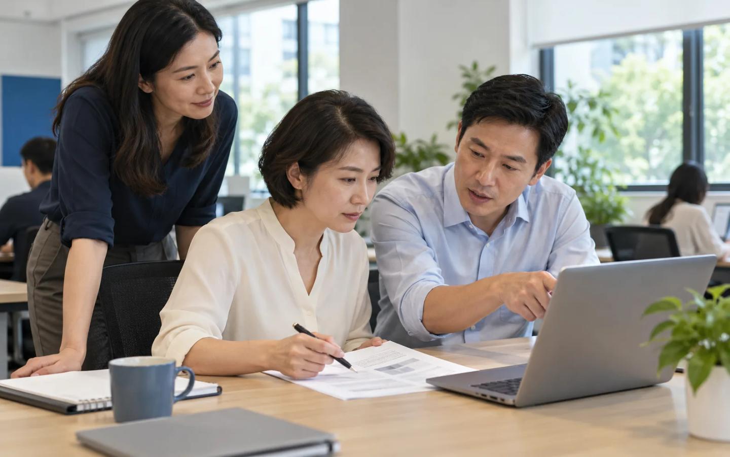 AI-generated illustration of colleagues checking a laptop draft against a printed source during guided practice.