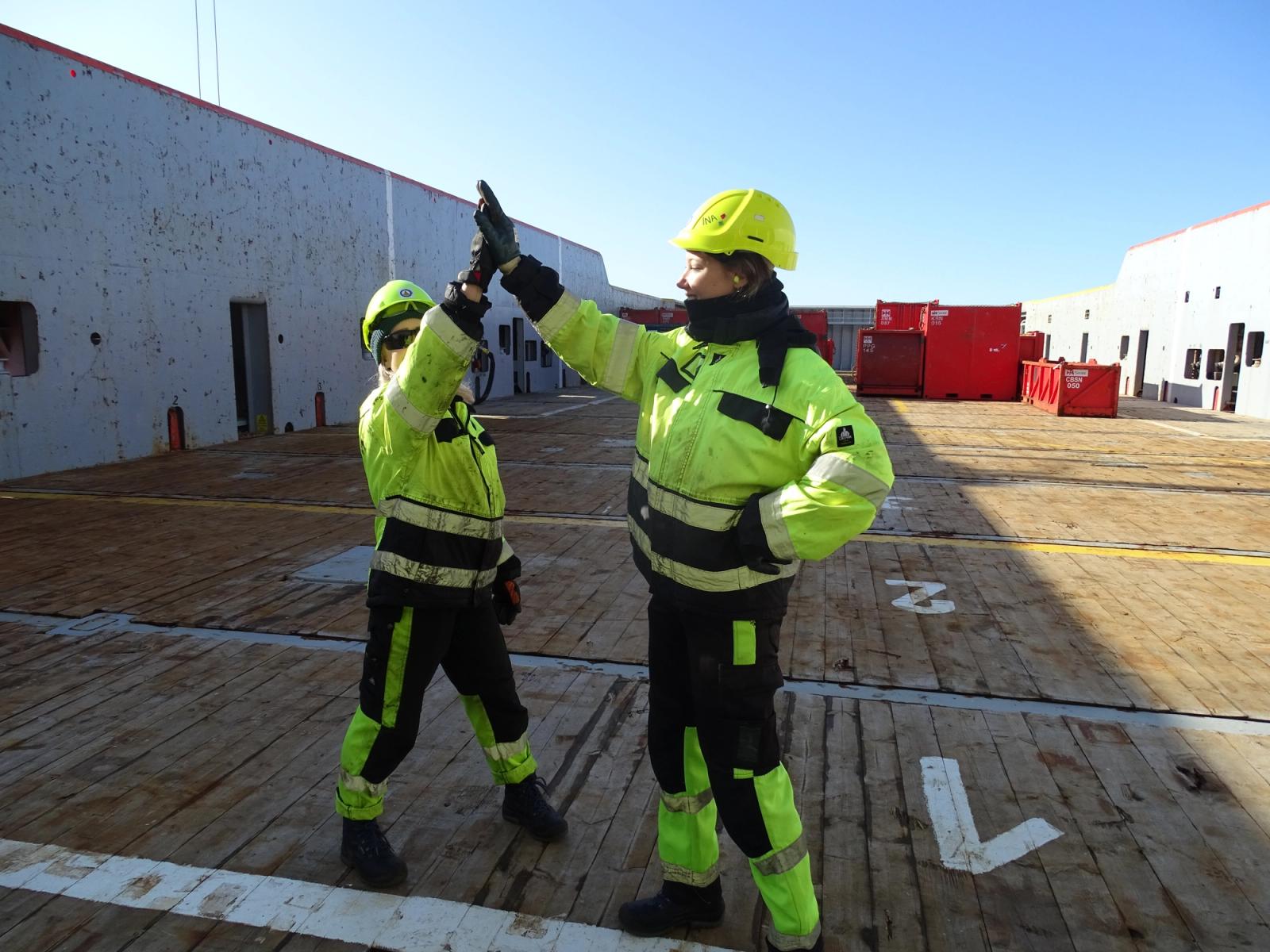 To personer som gjør high five på dekk