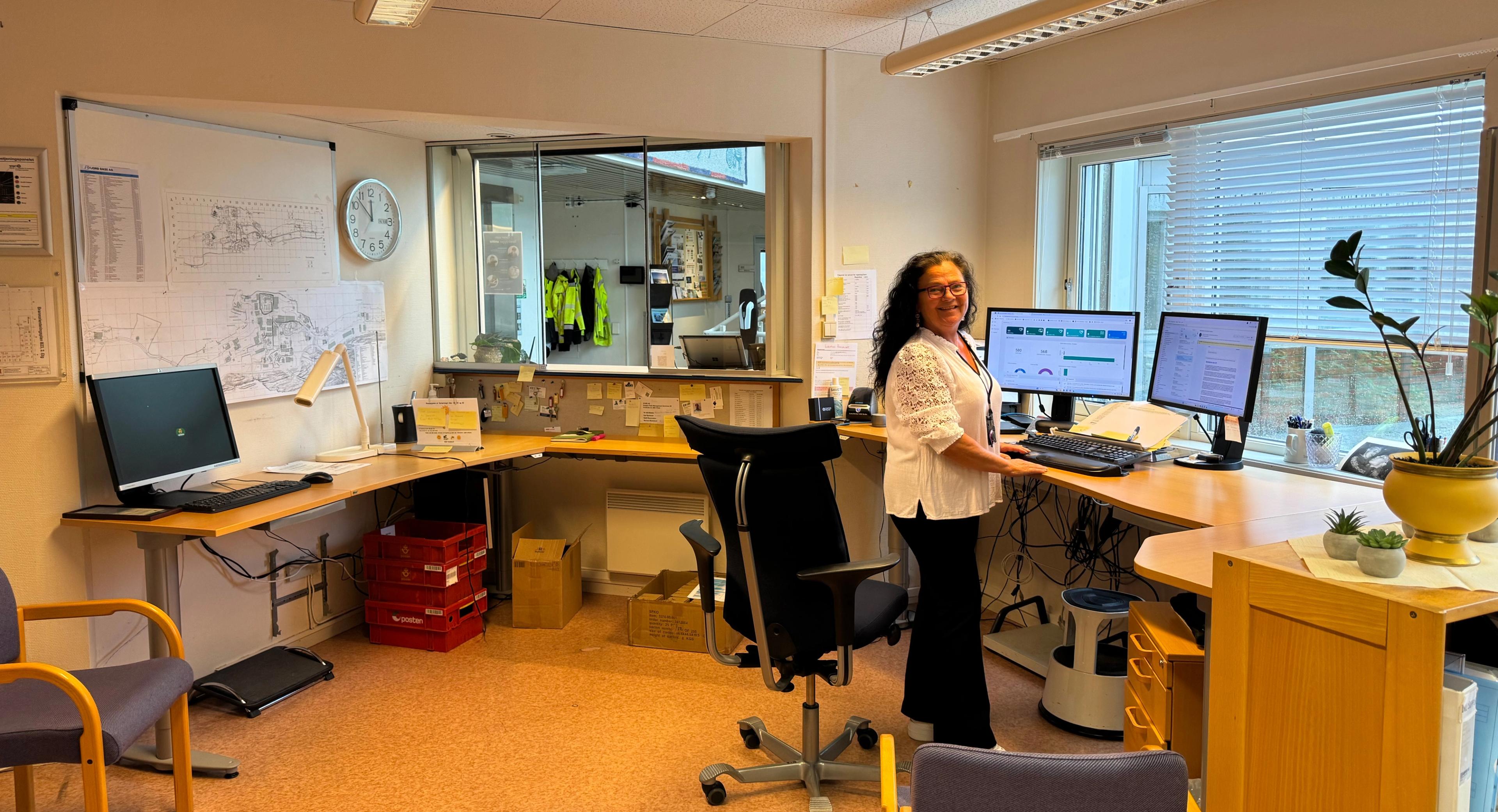 Kontorplassen hvor Margrethe holder oversikt gjennom dagen. Hun smiler mot kamera. Foto.