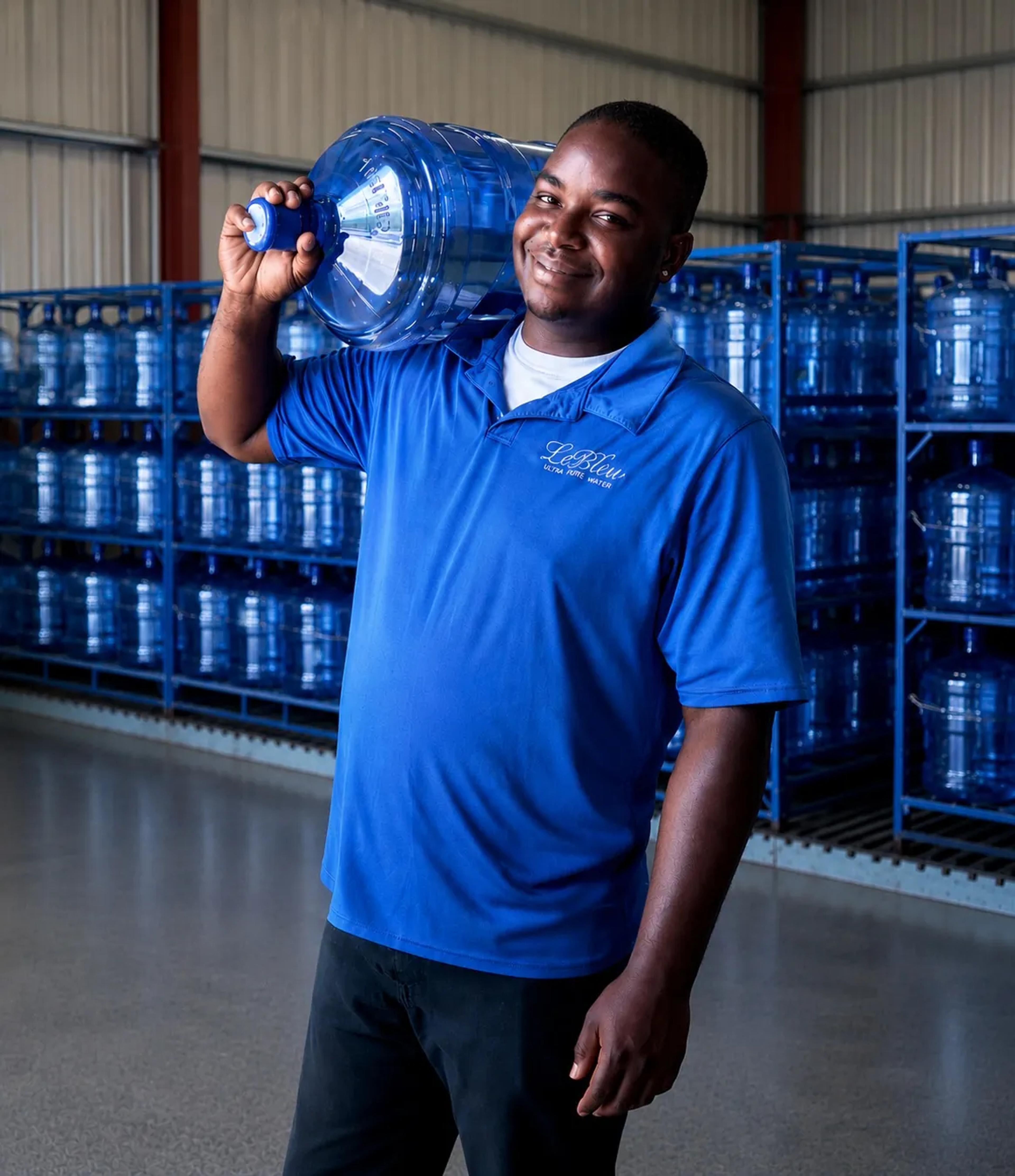 Le Bleu delivery professional carrying a 5-gallon water bottle