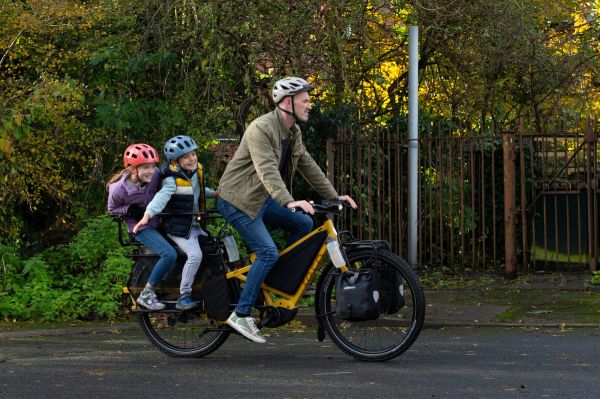 Parent riding a Tern Orox with a child on the back