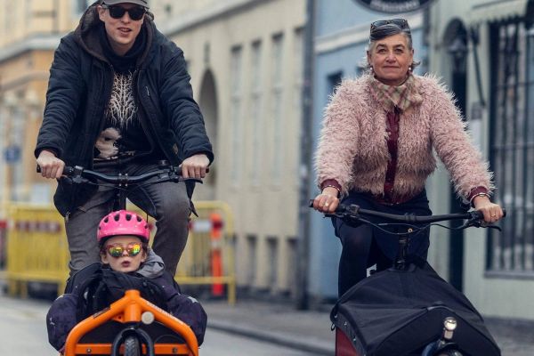 Two riders on Larry vs Harry Bullitts in a Copenhagen street, a child in the front box
