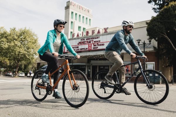 Two riders on Marin Fairfax bikes in front of the Fairfax theater