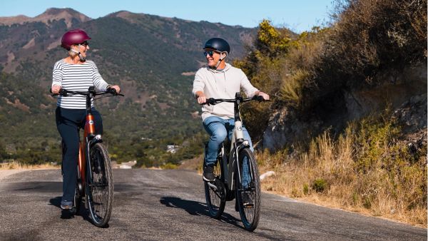 Two riders on Gazelle Arroyo e-bikes on a hillside road
