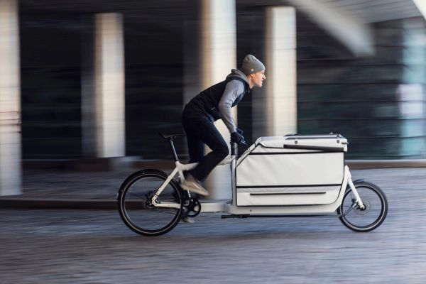 Larry vs Harry Bullitt X with a convoy box, rider passing under a Copenhagen bridge