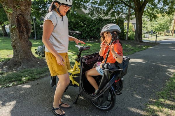 Parent helping a child into the seat of a Tern HSD
