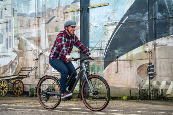 Rider on a Marin Sausalito e-bike passing a painted mural