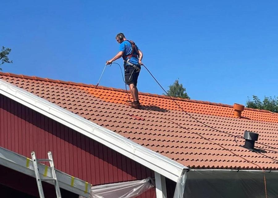 Takmålning pågår – sprutmålning av tegeltak med fallskydd