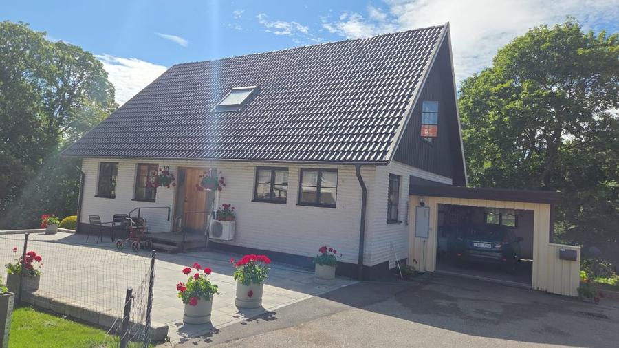 Nymålat tak i mörk kulör på vitt hus
