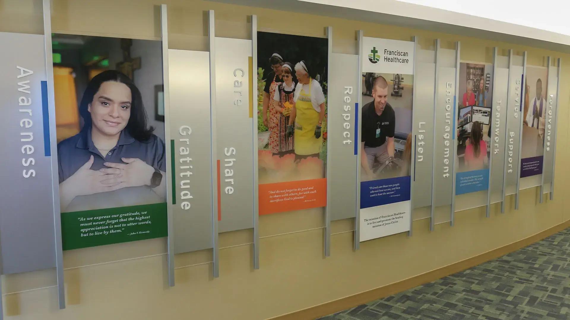 Franciscan Healthcare mission branding wall built with the Rail Wall System featuring values panels, photography, and patient-centered messaging.