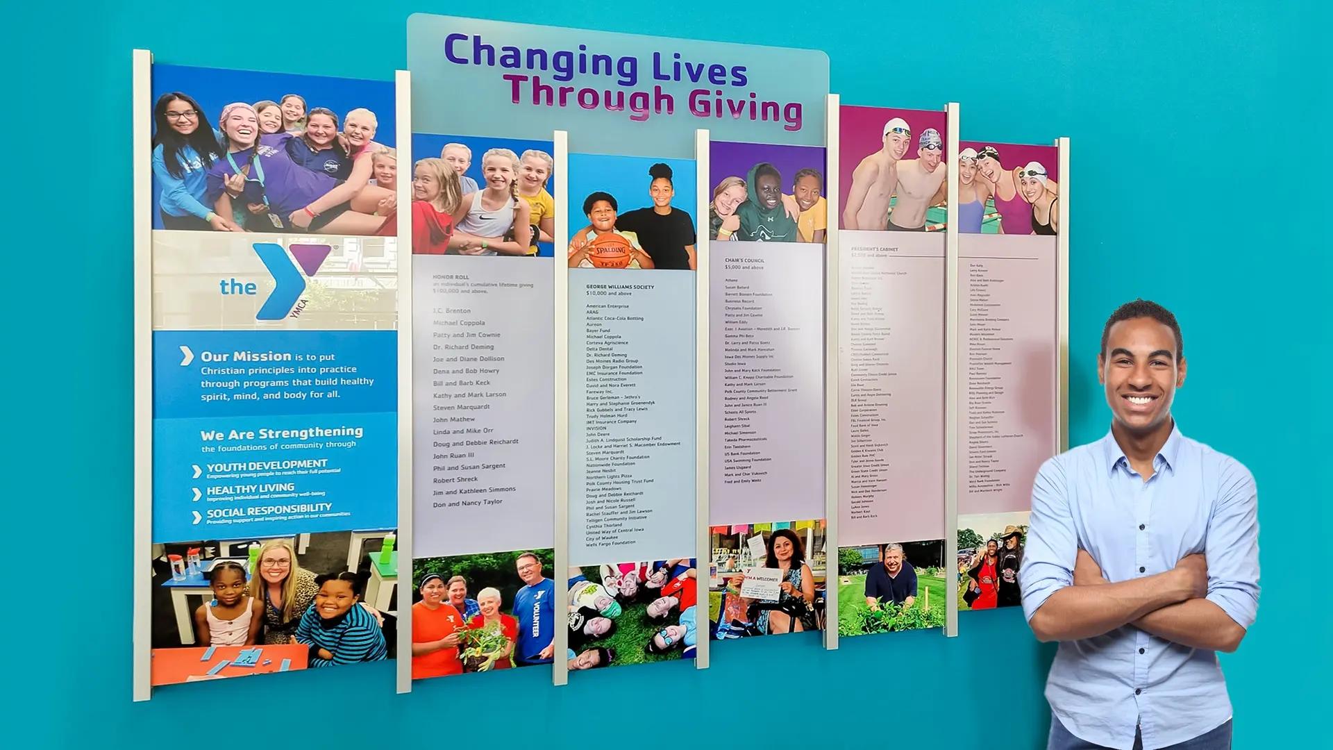 YMCA donor recognition wall with updateable panels, community photos, and colorful Rail Wall System design.