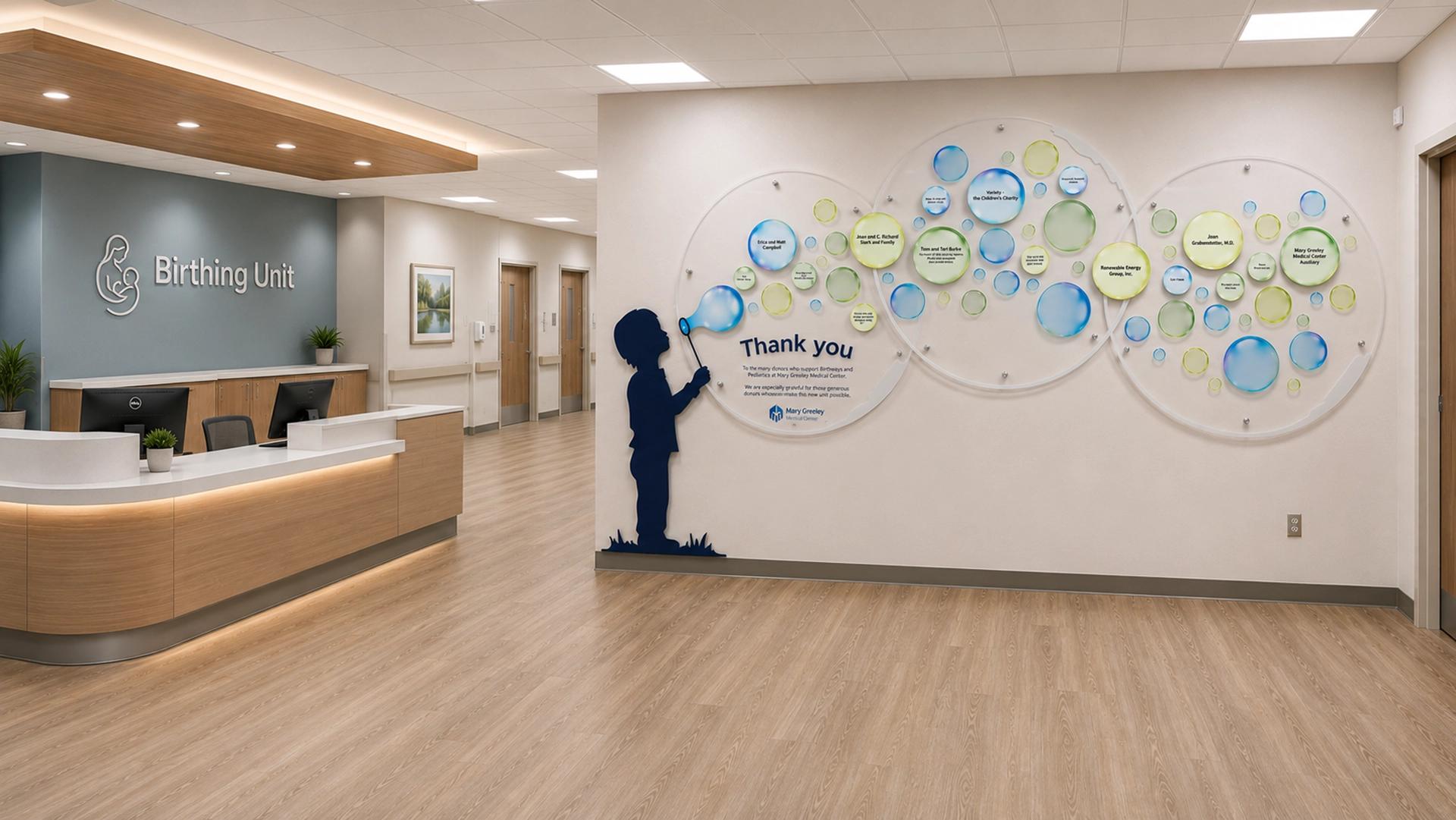 Birth and pediatric hospital unit bubble donor wall featuring colorful individual donor name bubbles and child silhouette blowing bubbles.