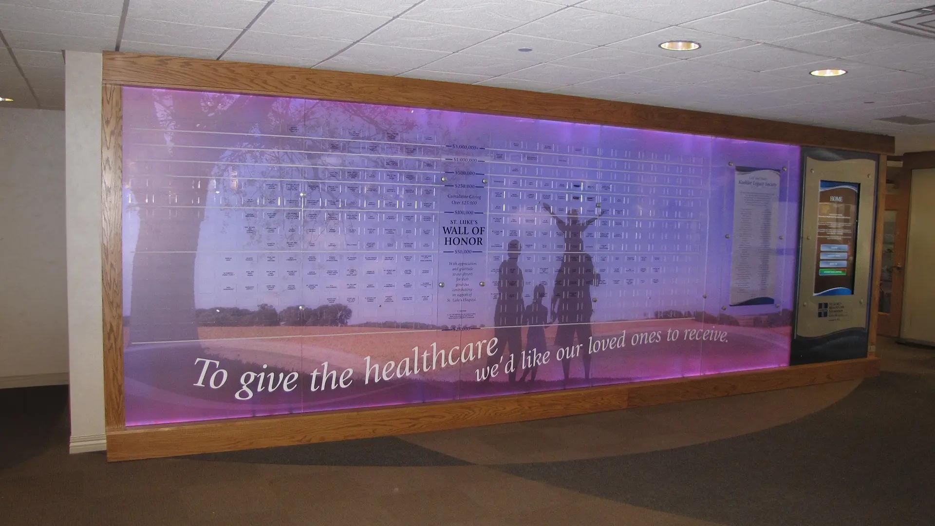 UnityPoint digital donor recognition wall with LED-lit panels with moveable donor tiles and touchscreen for cumulative, annual, and legacy giving.