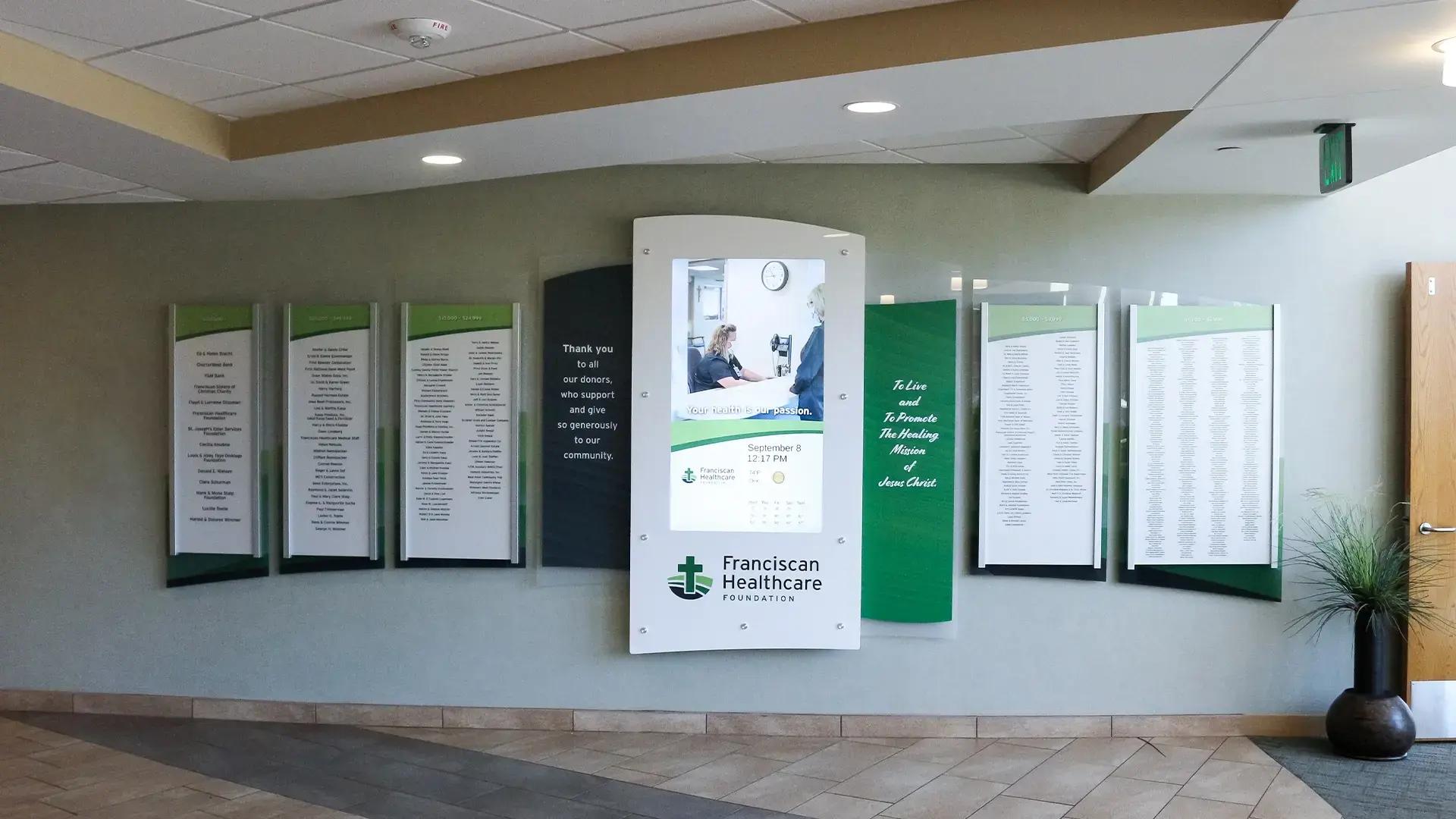Digital donor recognition wall with portrait touchscreen, custom panels, and donor names at Franciscan Healthcare Foundation, powered by Arreya.