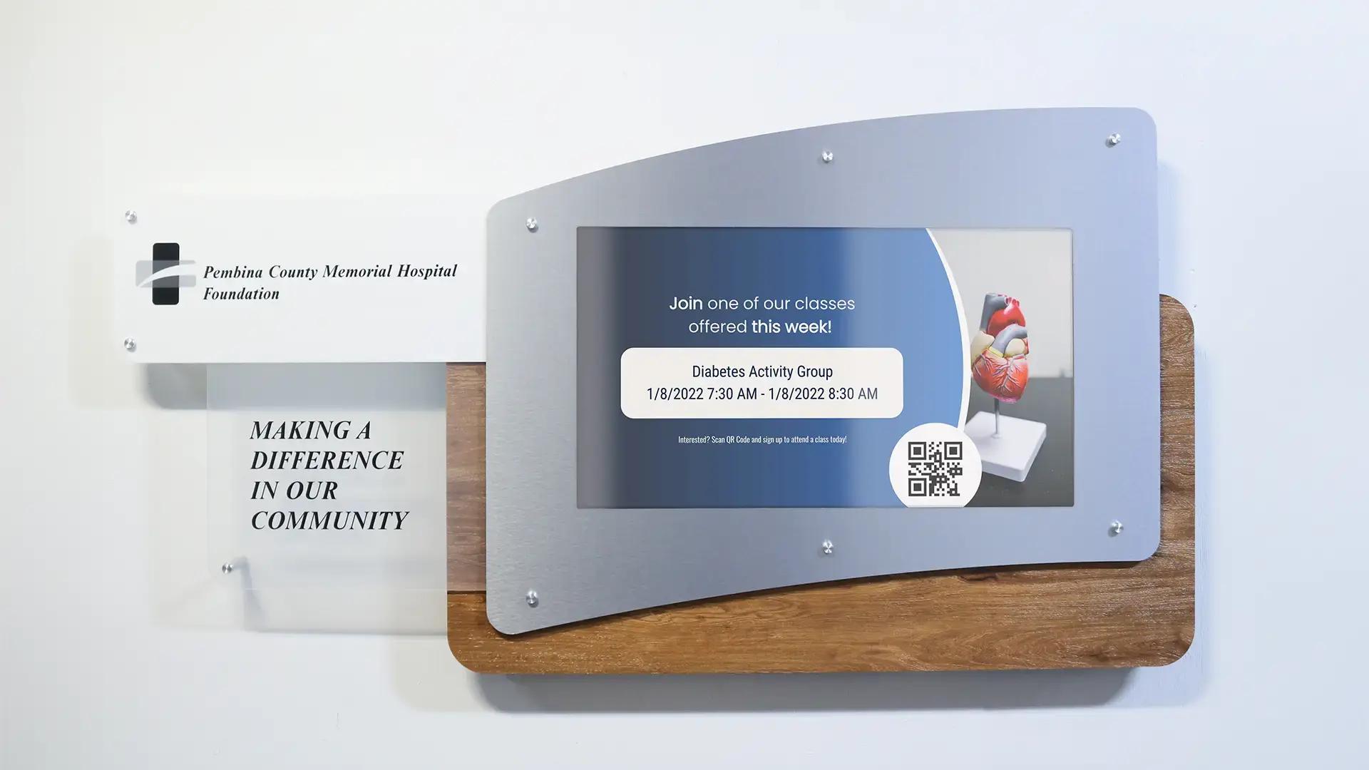 Custom branded digital donor display kiosk with aluminum surround, wood backing at Pembina County Memorial Hospital Foundation, powered by Arreya.