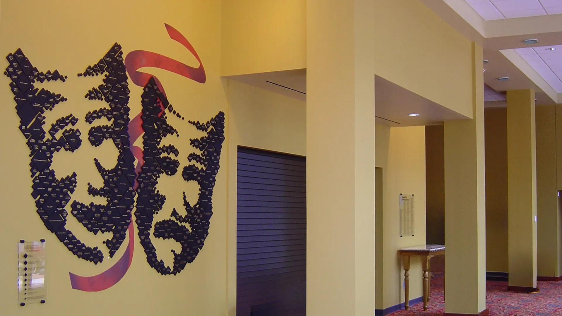 Paramount Theater pointillist tile donor wall forming a theatrical mask design in a lobby space.